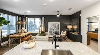 A modern kitchen with a large island and a dining area.
